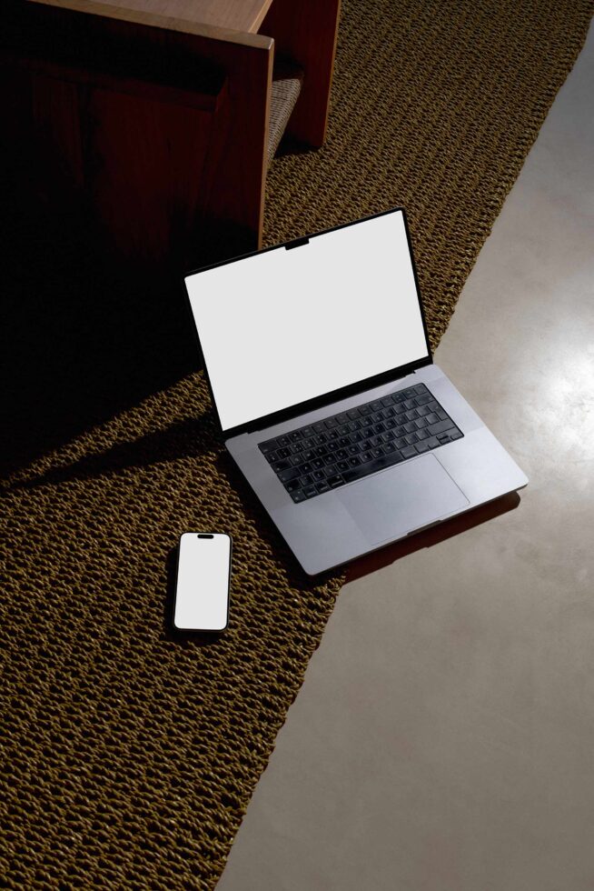 Laptop with blank screen, phone with blank screen on textured floor