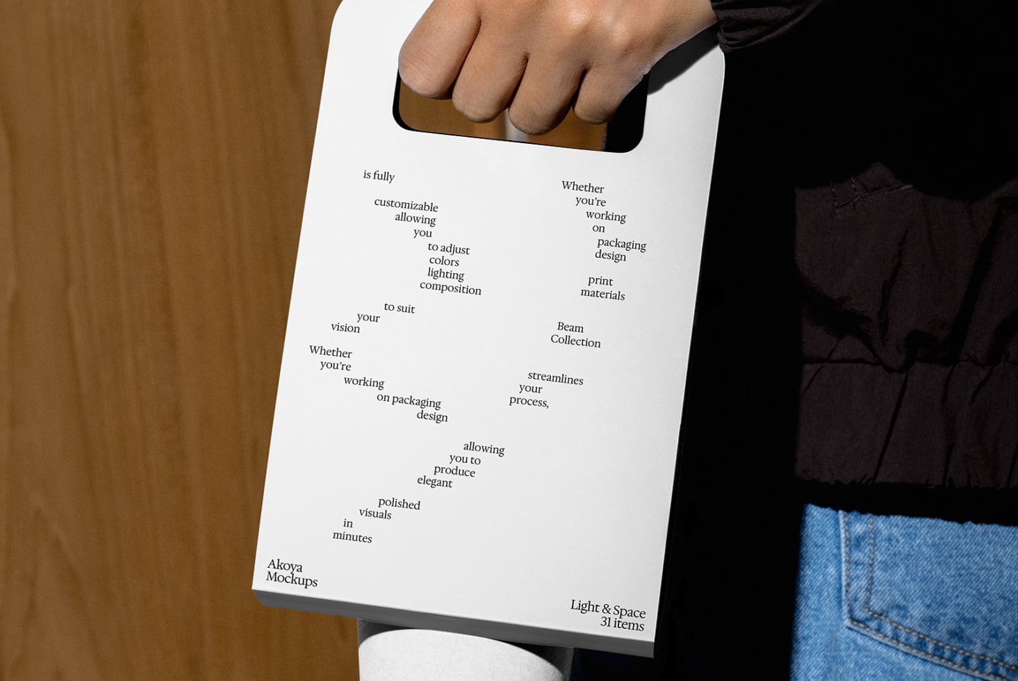 Hand holding printed sheet with scattered text about customizable mockup design