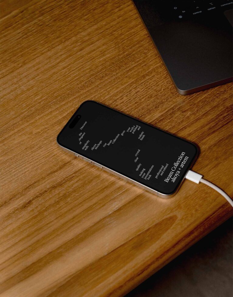 Black phone on wooden desk showing dark interface with white text design