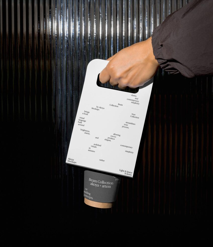 White shopping bag with scattered text held by hand in sunlight
