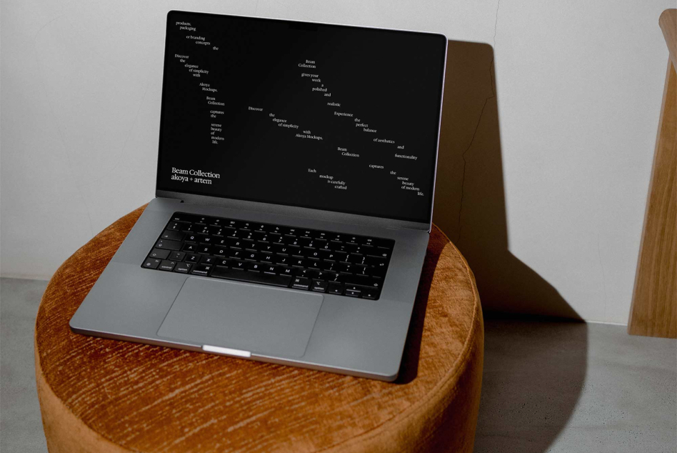 Laptop on wood table showing website design layout with black background
