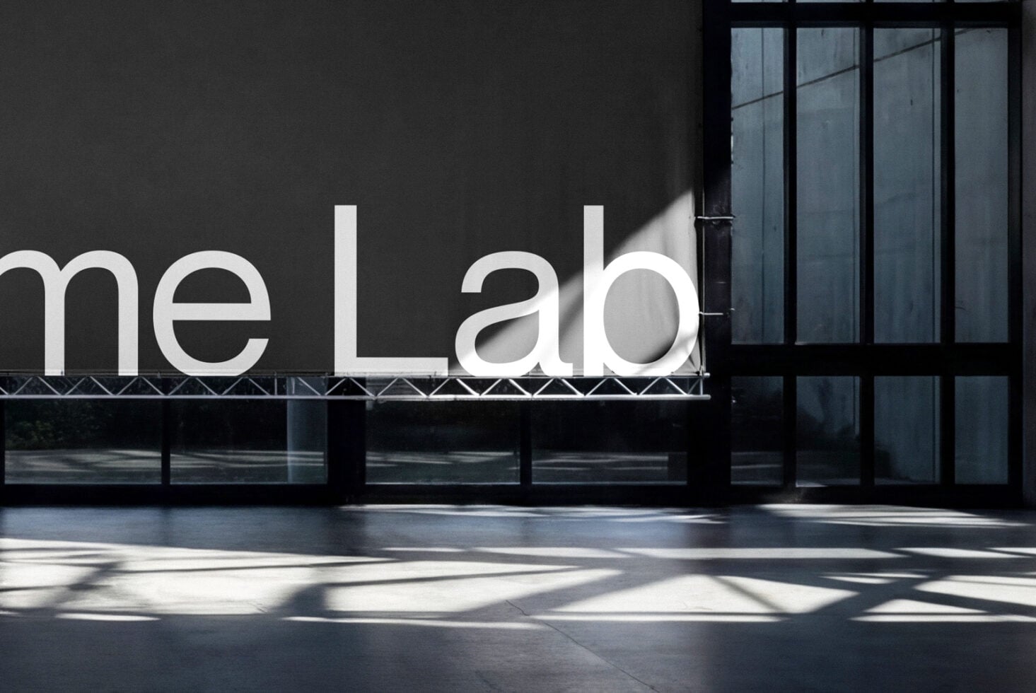 Modern storefront with white neon me Lab signage on dark facade with windows