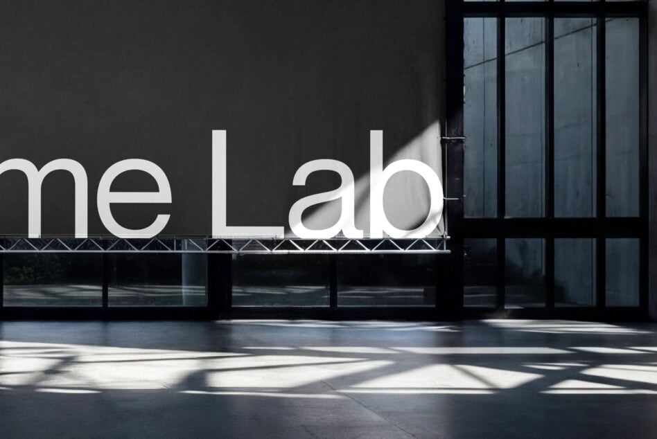 Modern storefront with white neon me Lab signage on dark facade with windows