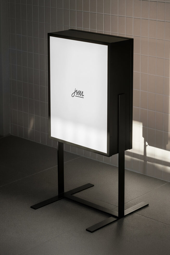 Black metal display stand with white vertical panel in minimalist gallery space