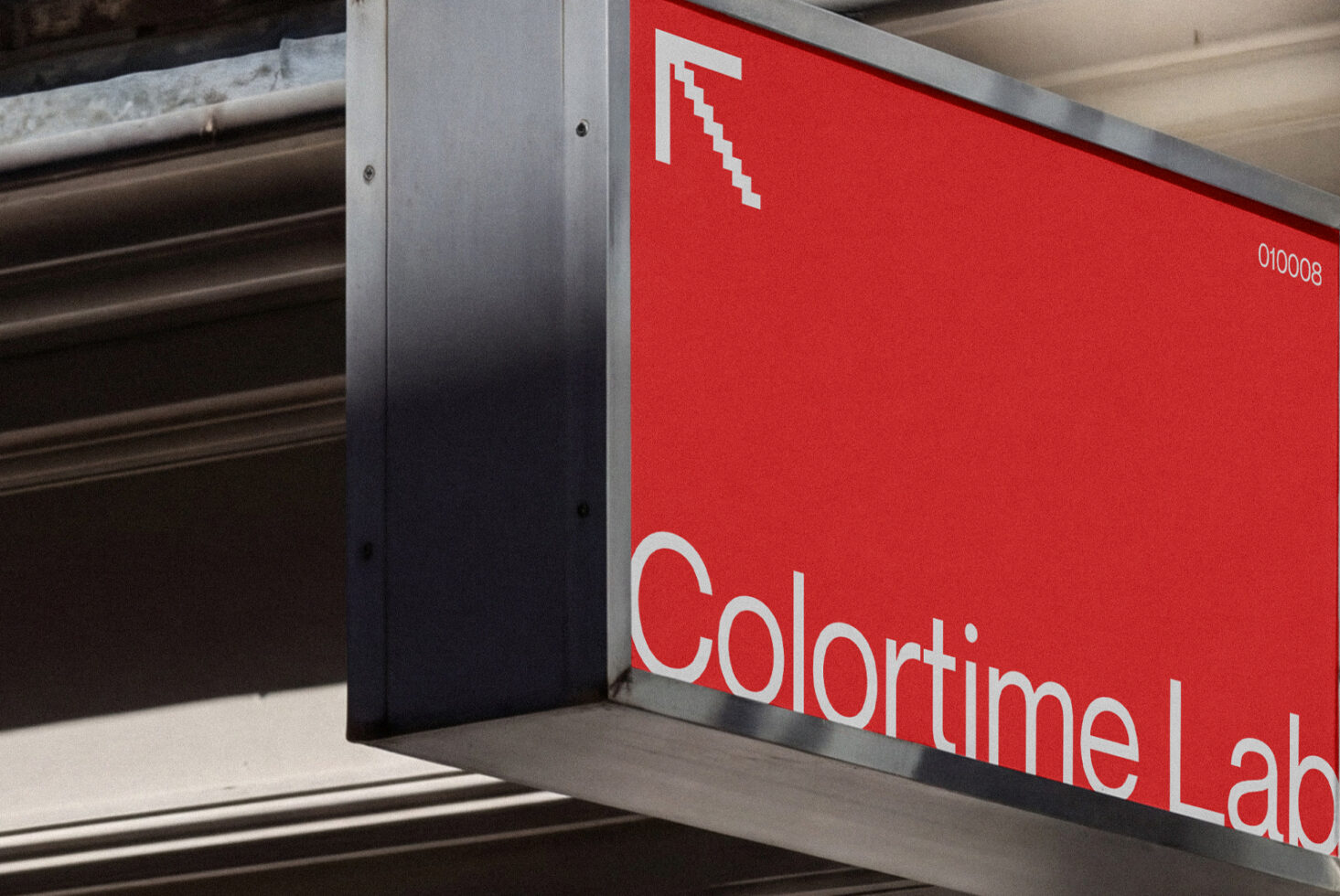 Bright red storefront sign with white text mounted on brick building facade