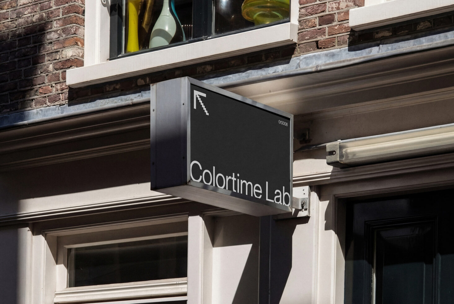 Dark business signage with white text on urban storefront with exposed brick