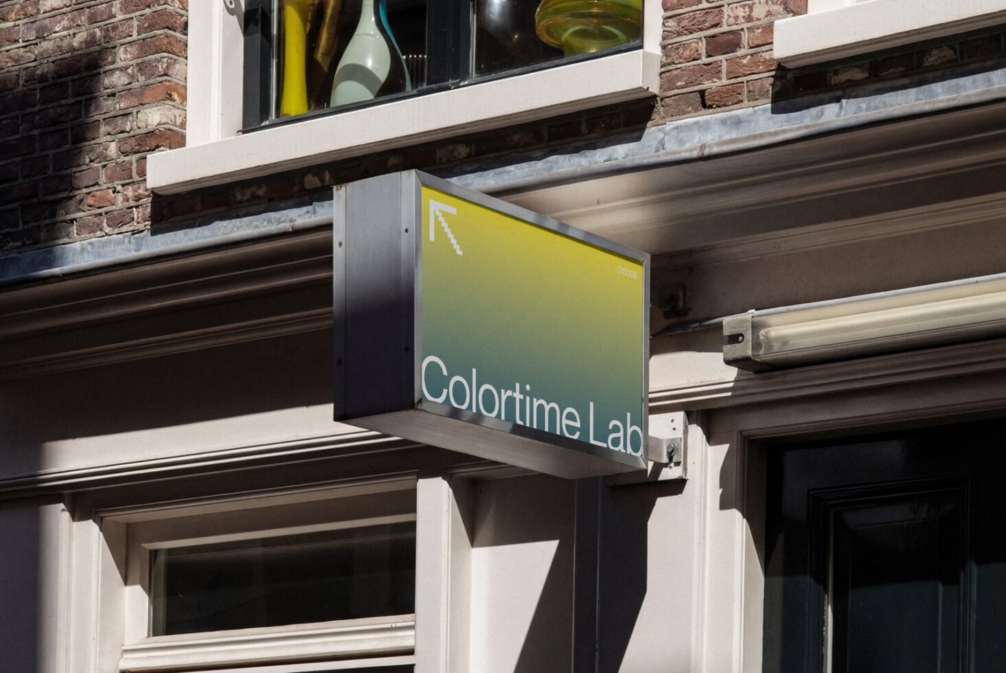 Yellow gradient storefront signage displaying brand name on city storefront