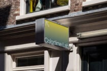 Yellow gradient storefront signage displaying brand name on city storefront