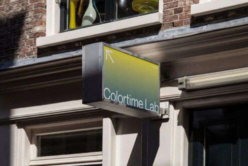 Yellow gradient storefront signage displaying brand name on city storefront