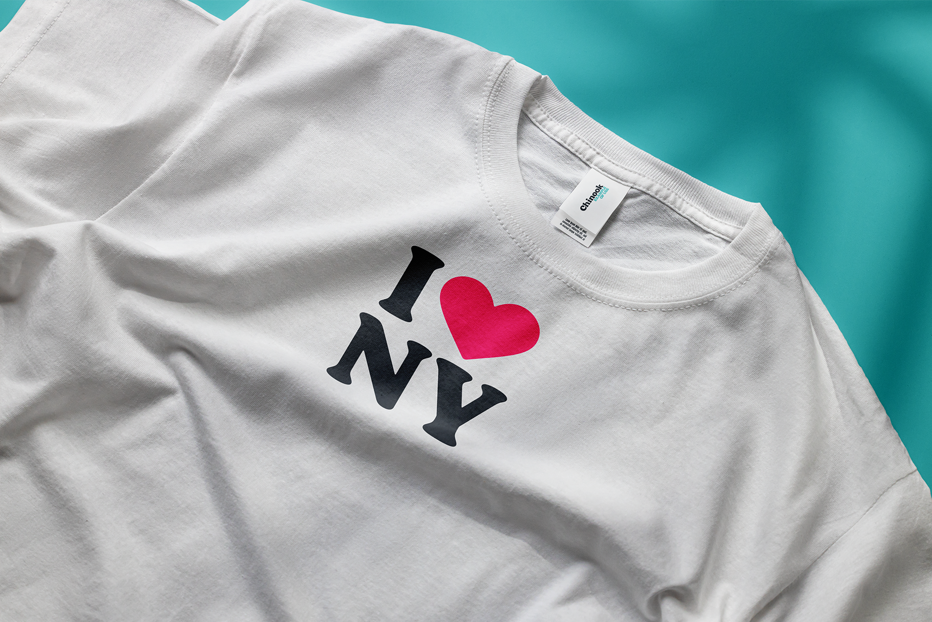 White tee with I love NY print in black letters with hot pink heart on turquoise background