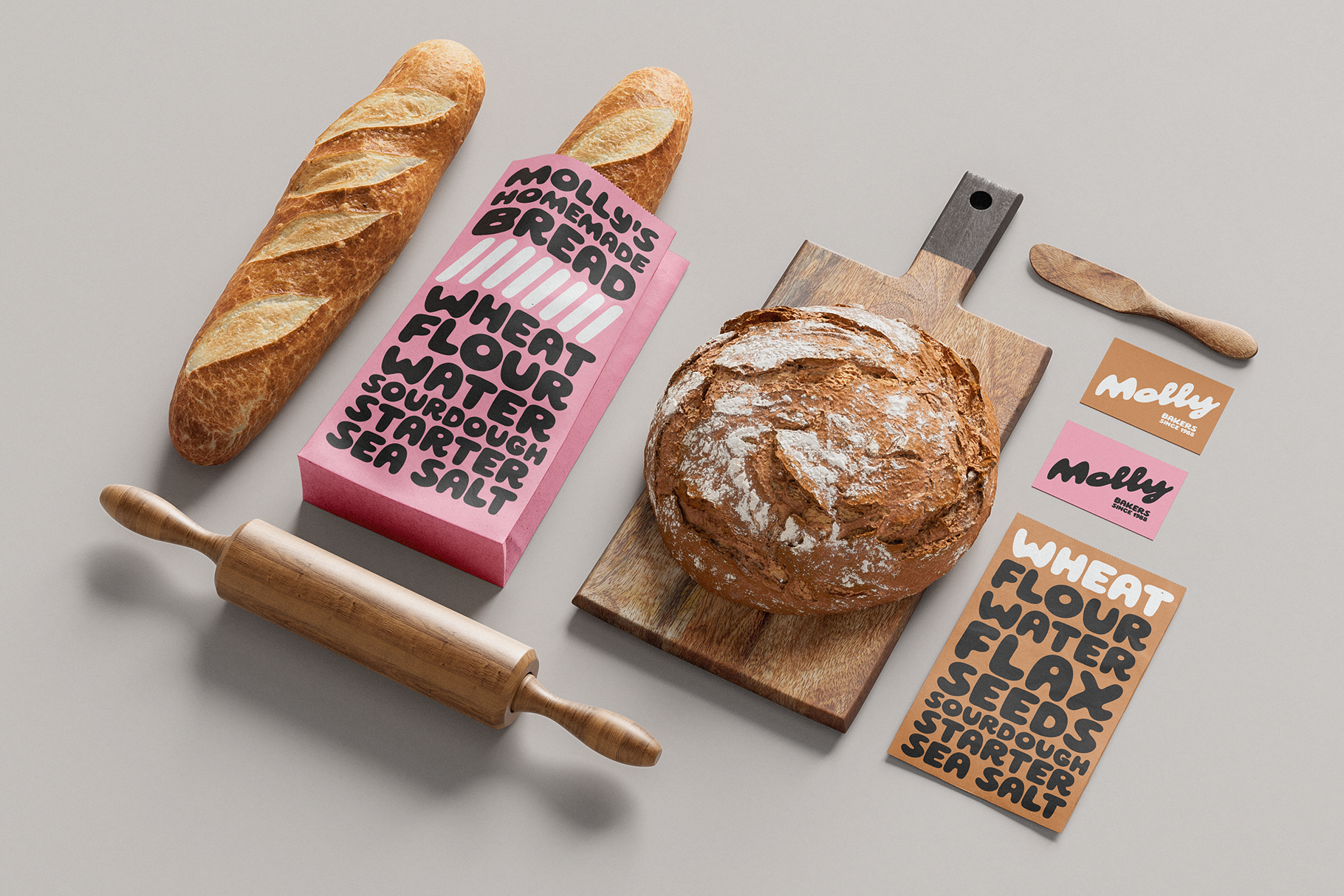 Flatlay of bread bakery branding with pink box, wooden tools, business cards