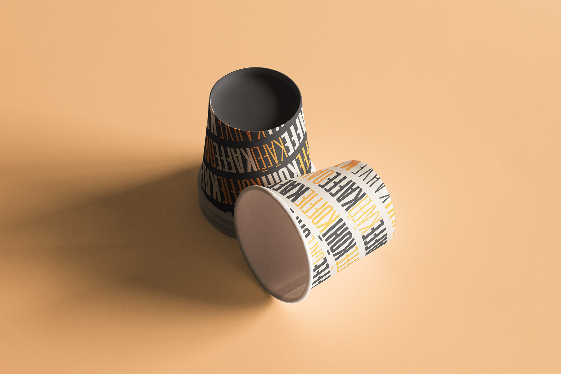 Two tapered cups with geometric stripe pattern in black, white, orange on tan background