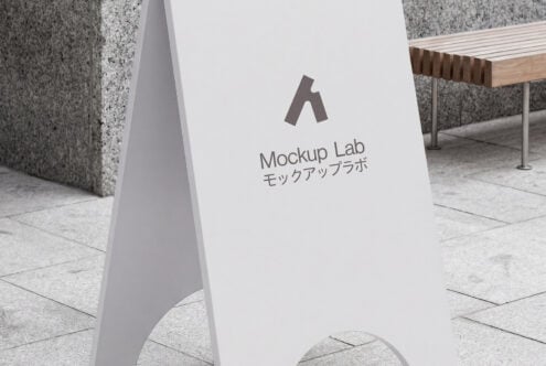 Minimalist white A-frame sign displayed on concrete storefront