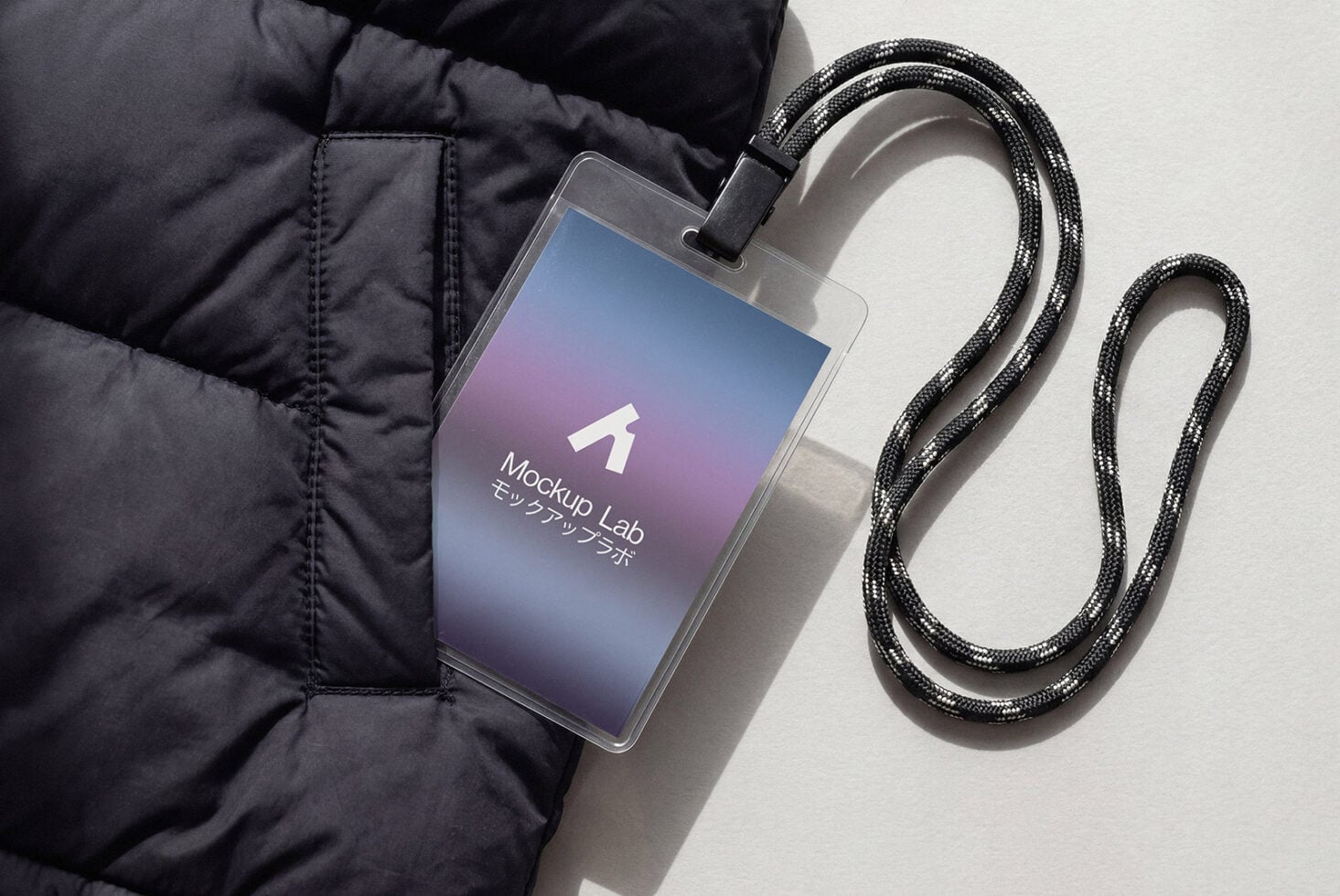 Phone with gradient screen attached to black braided cable on dark jacket