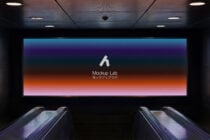 Escalator tunnel billboard showing vibrant gradient on bright display