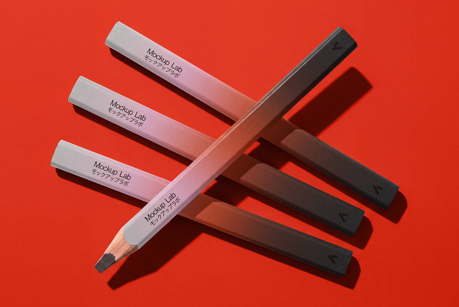Colored pencils in white, pink, black arranged on bright red background with shadows