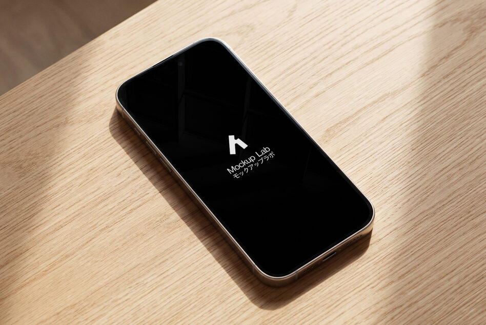 Smartphone on wooden desk with black screen showing Mockup Lab logo