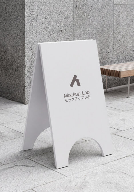 Blank white A-frame pavement sign on outdoor stone plaza