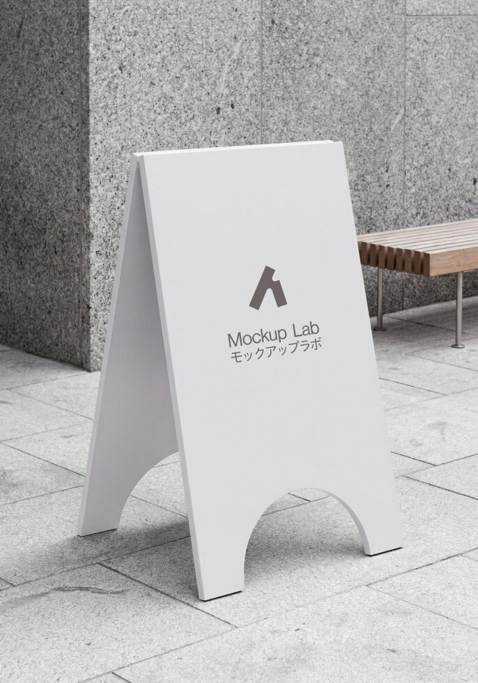 Blank white A-frame pavement sign on outdoor stone plaza