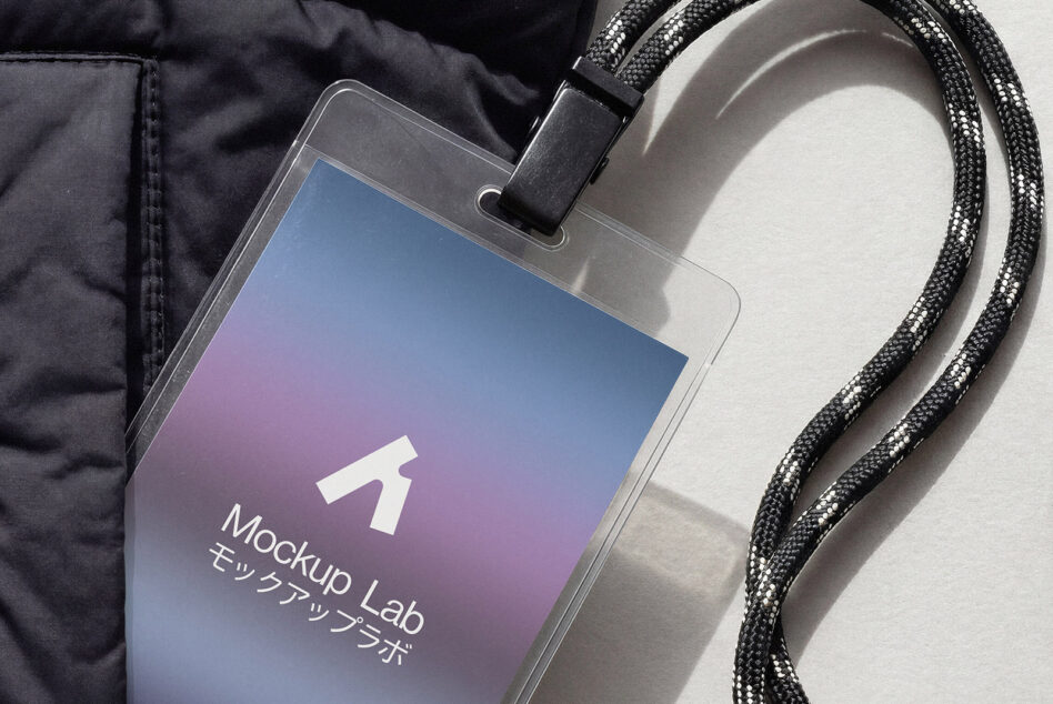 ID badge with gradient design clipped to braided cord lanyard, jacket visible