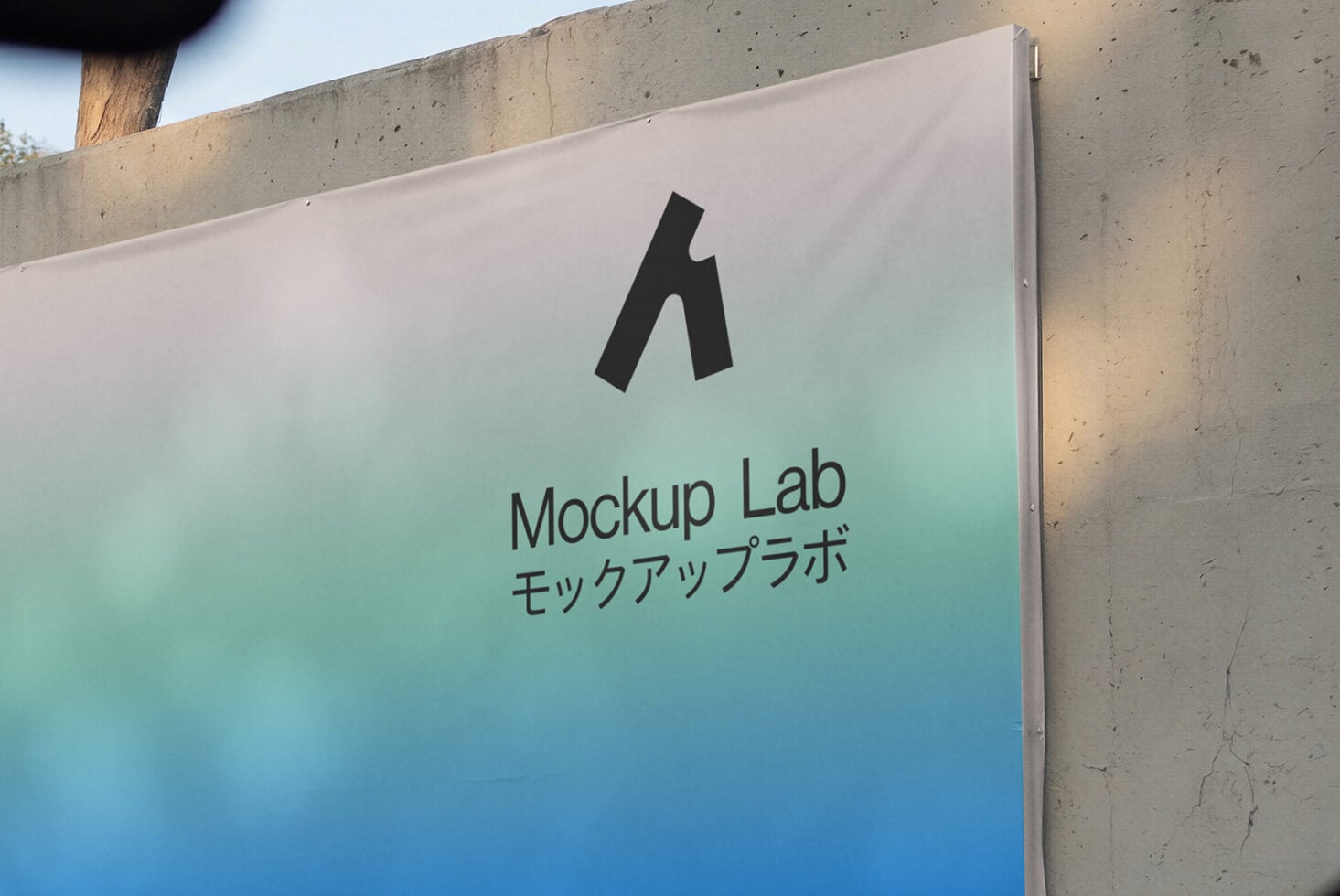 Angled concrete sign with turquoise gradient displaying Mockup Lab logo, trees visible