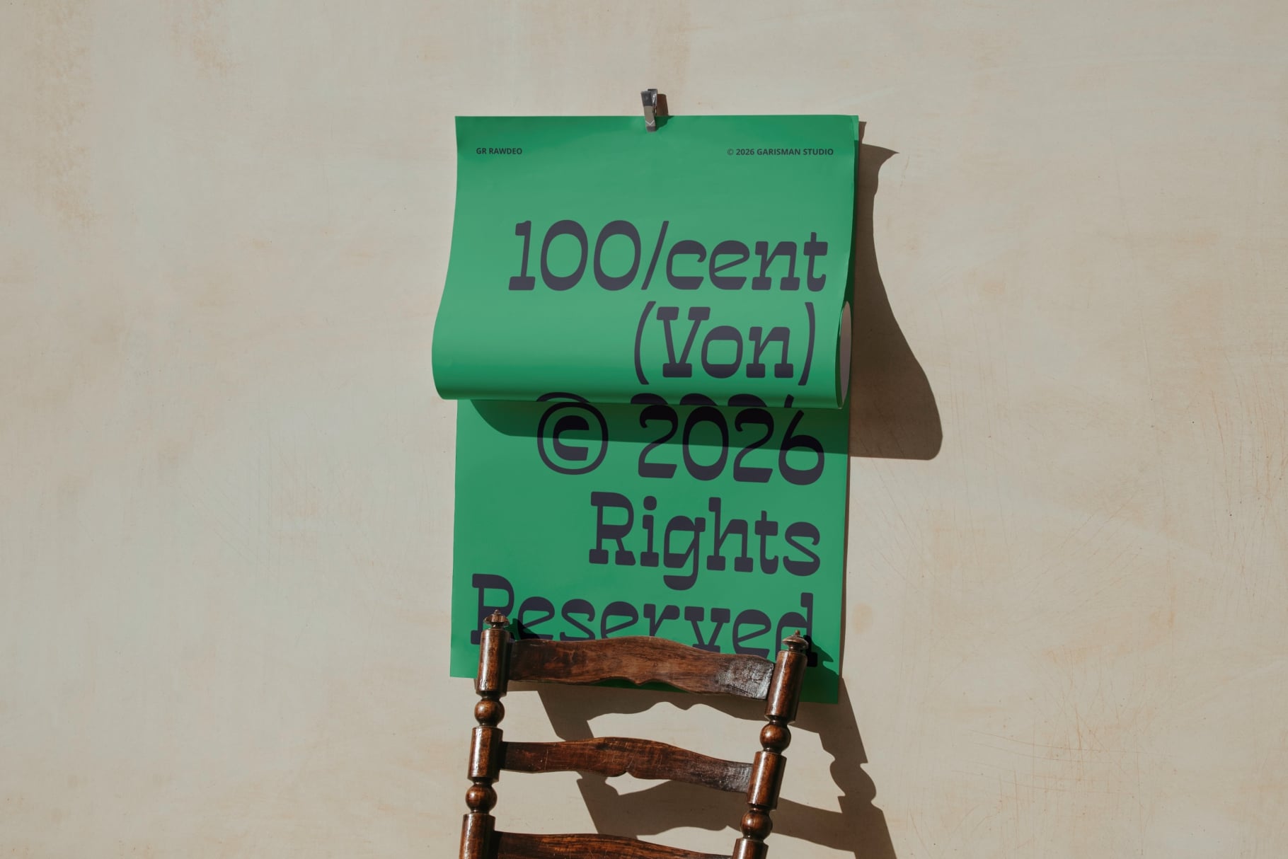 Green paper clipped to wooden chair back with copyright text in purple
