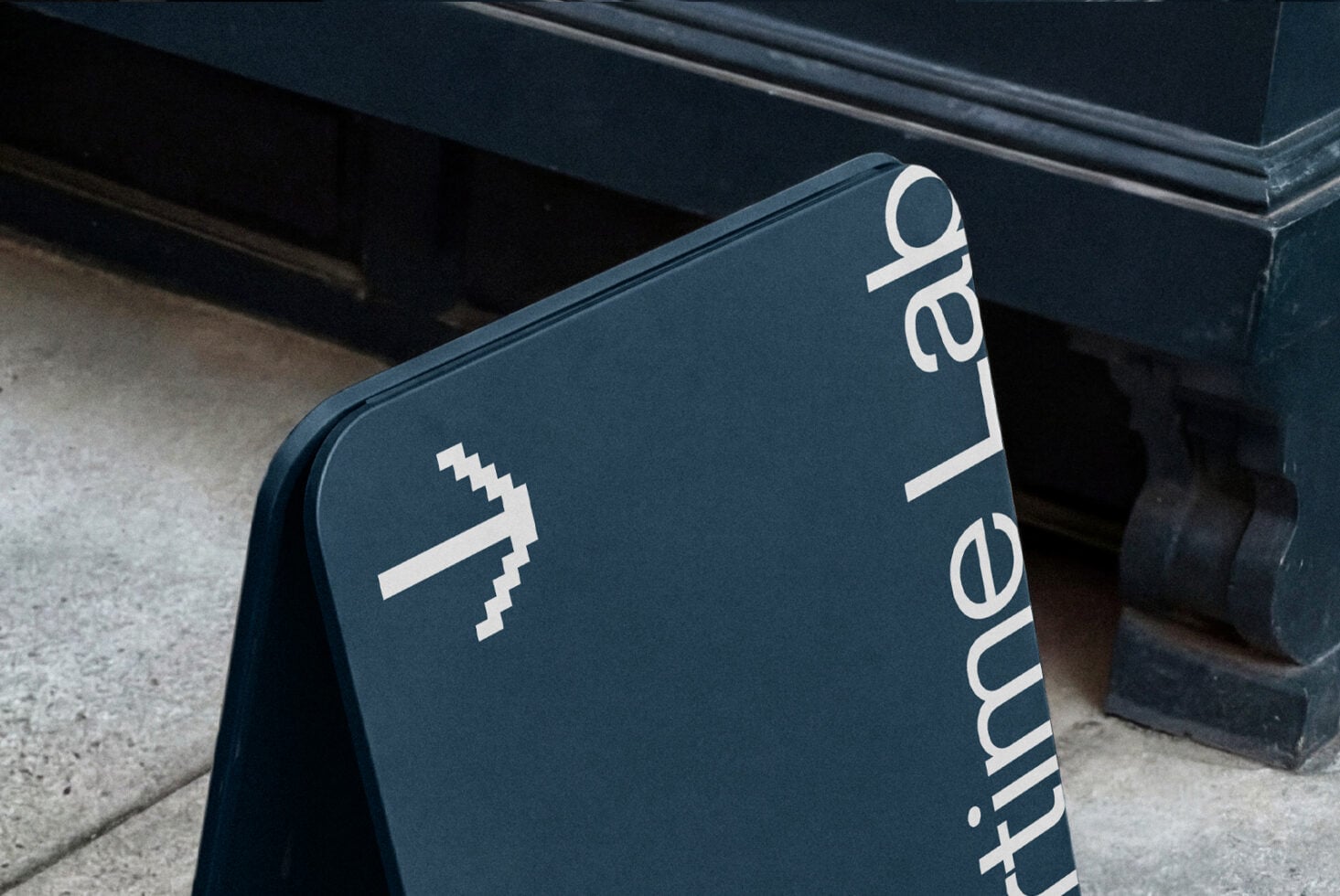 Dark teal A-frame sidewalk sign with Coordinate Lab branding vertical