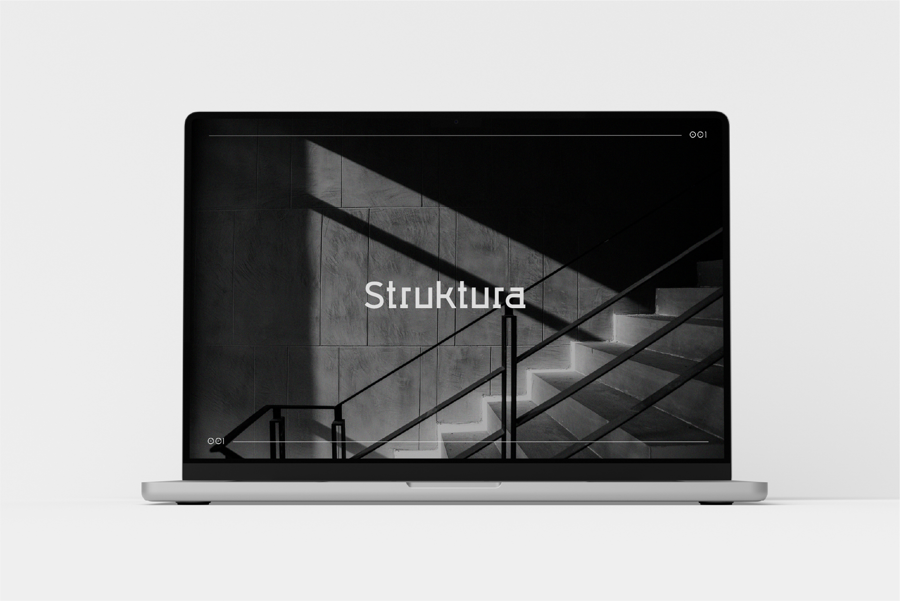 Laptop mockup displaying Struktura website with architectural staircase photography