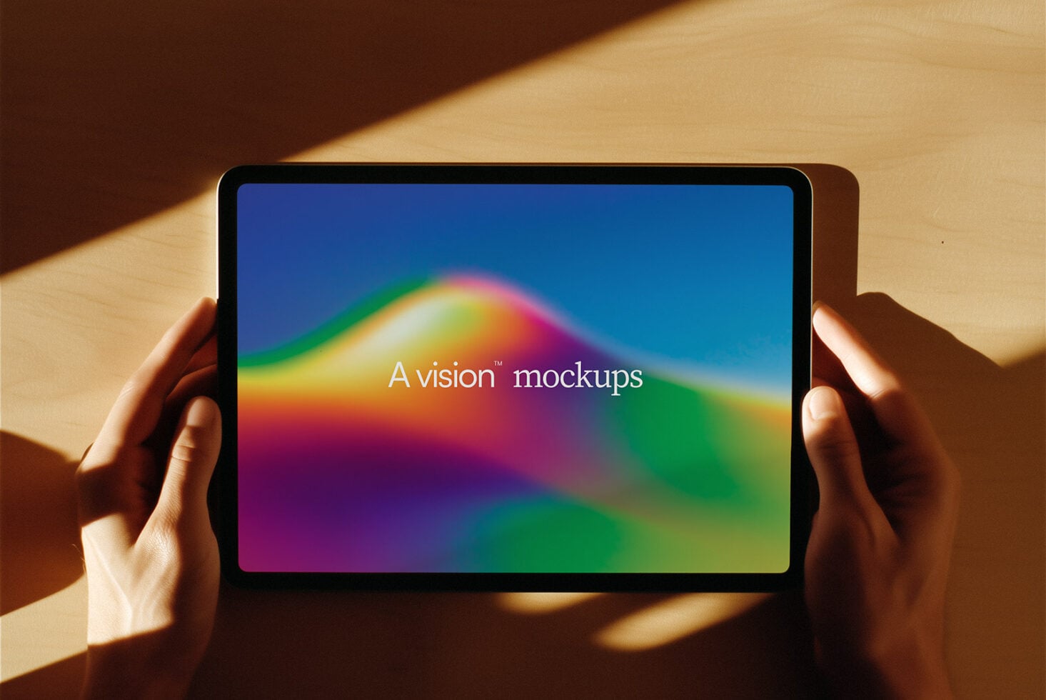 Person gripping tablet displaying vibrant gradient design with warm lighting
