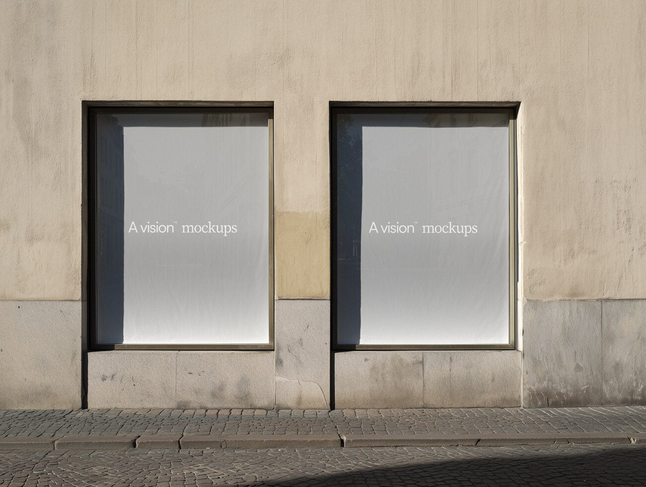 Concrete storefront facade with two black-framed blank poster mockups side by side