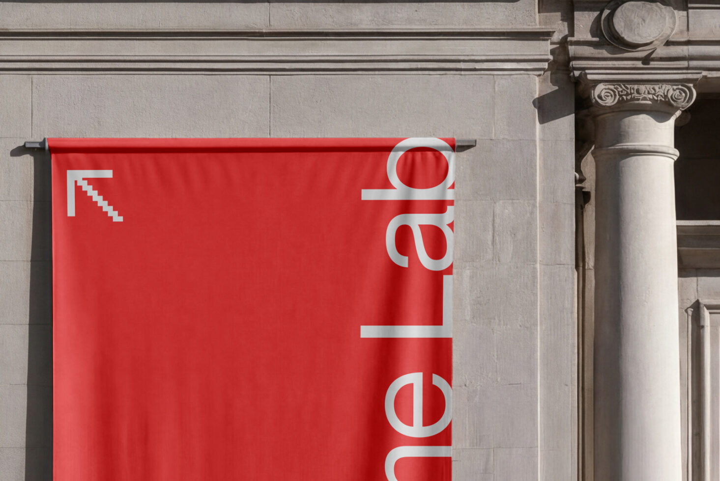 Red banner hanging on neoclassical building with diagonal arrow logo
