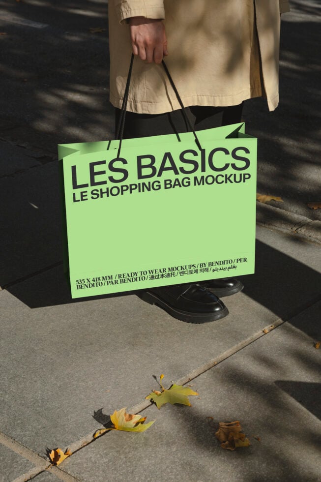 Neon lime shopping bag held by person in beige coat on concrete sidewalk