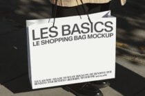Off-white retail bag mockup carried outdoors with shadow detail