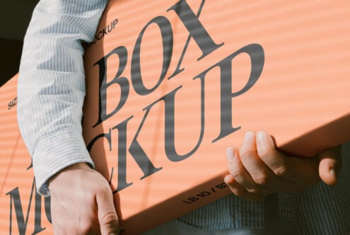 Hands holding peach colored paper with serif typography mockup in sunlight