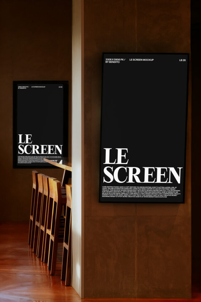 Two black framed posters on warm brown wall with wooden chairs below