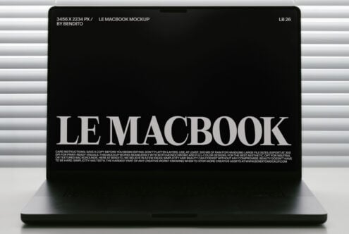 MacBook mockup with black screen showing white serif text against horizontal blinds backdrop