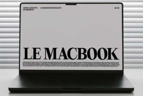 MacBook mockup with light screen displaying black serif typography in minimalist window setting