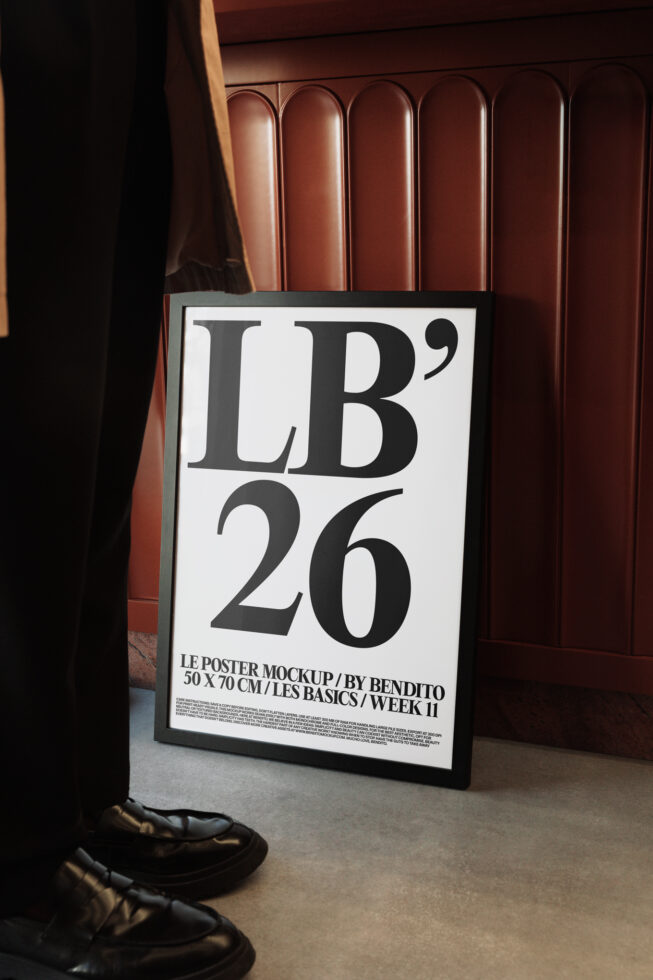 Framed poster mockup with white background displaying bold serif typography in interior setting