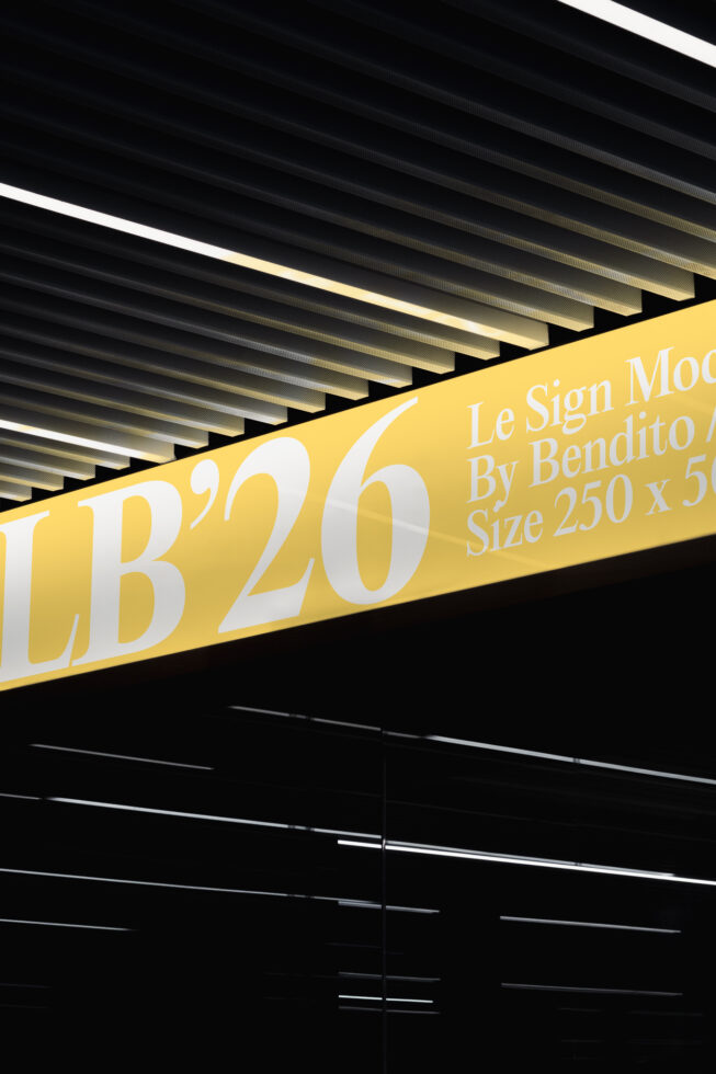 LB'20 sign mockup on yellow banner with ceiling slats, serif typeface