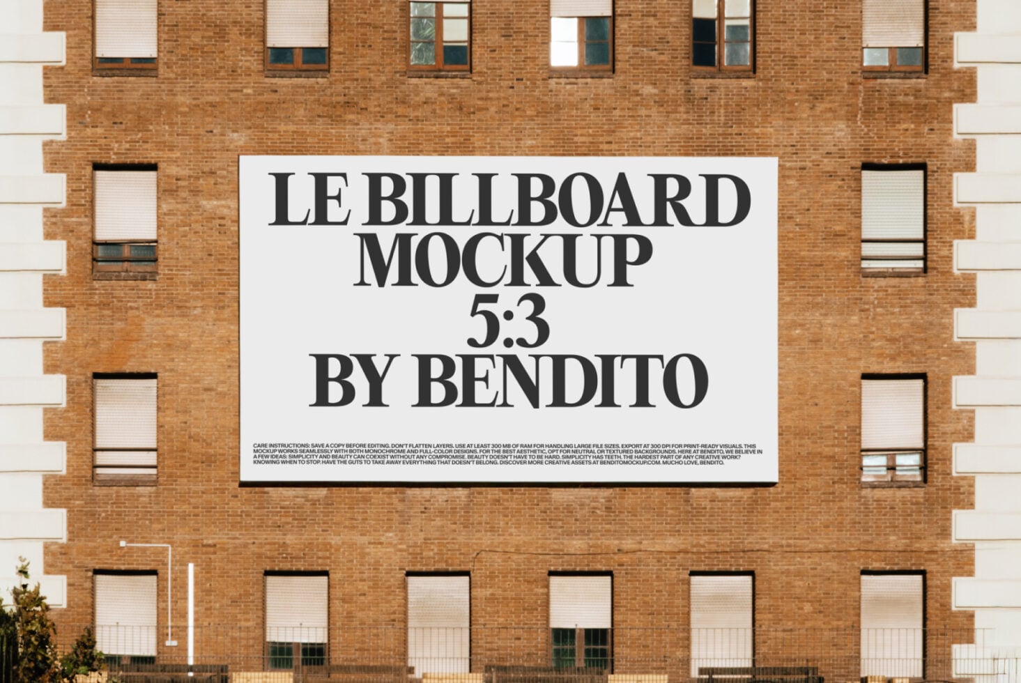 White billboard on brick building displaying Le Billboard Mockup 5:3 by Bendito