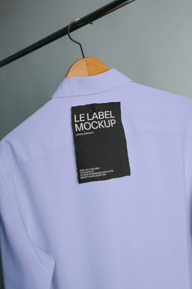 Black fabric label mockup pinned to lavender shirt on wooden hanger