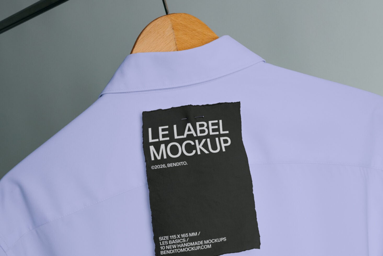 Black care label mockup stitched to purple button-up shirt on wooden hanger