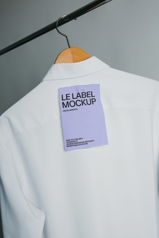 Periwinkle label mockup attached to white shirt displayed on wooden hanger