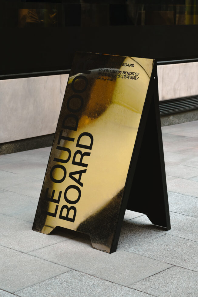 Yellow outdoor board mockup angled on pavement with dark shadows