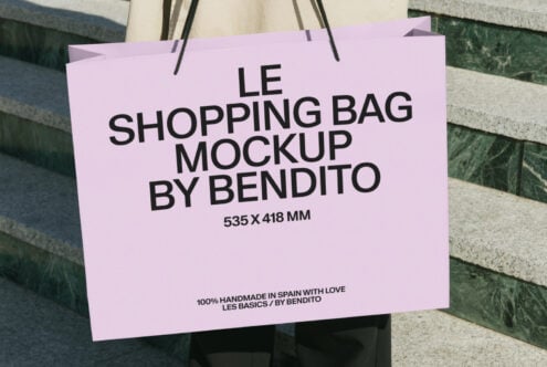 Pink shopping bag mockup held in front of stone wall background