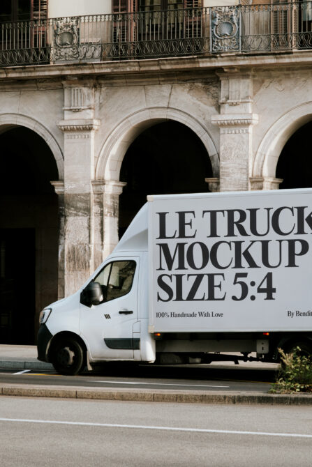 White delivery truck side view against classical architecture with navy signage