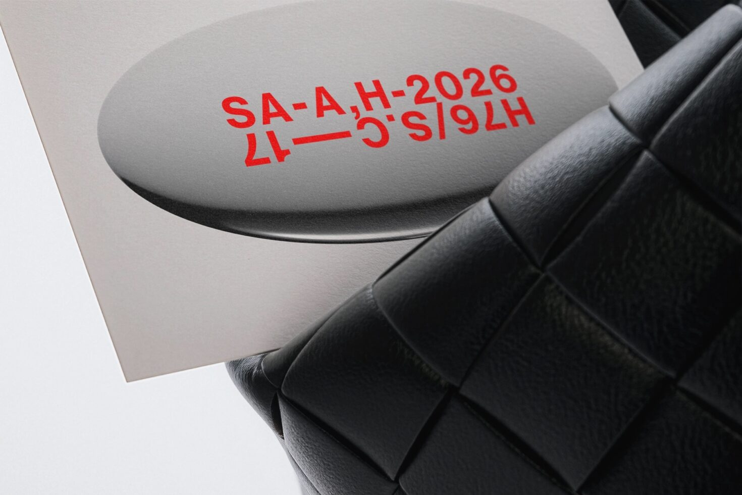 Black quilted bag with gray oval tag showing red text stamp