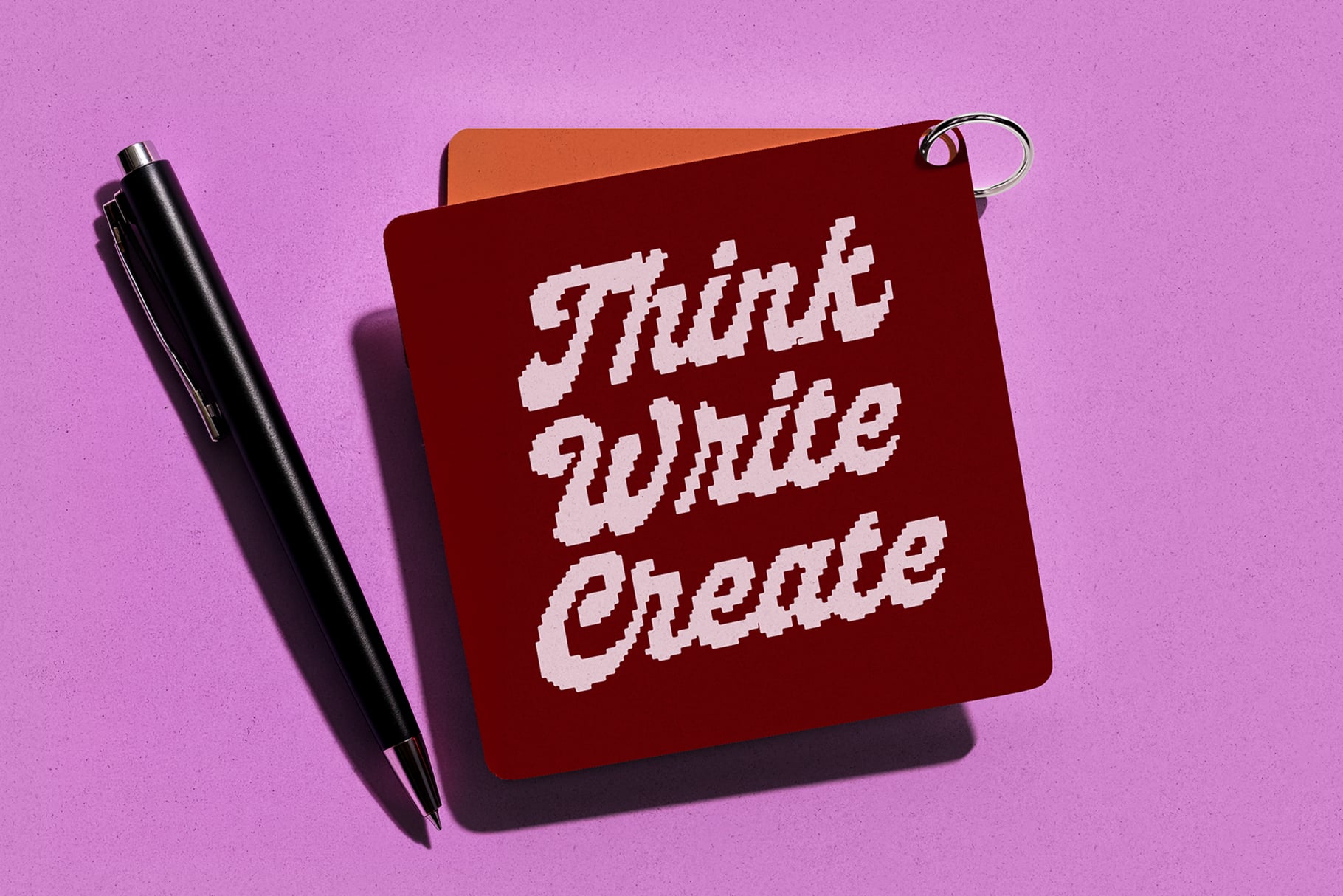 Red keychain charm with white pixelated text Think Write Create
