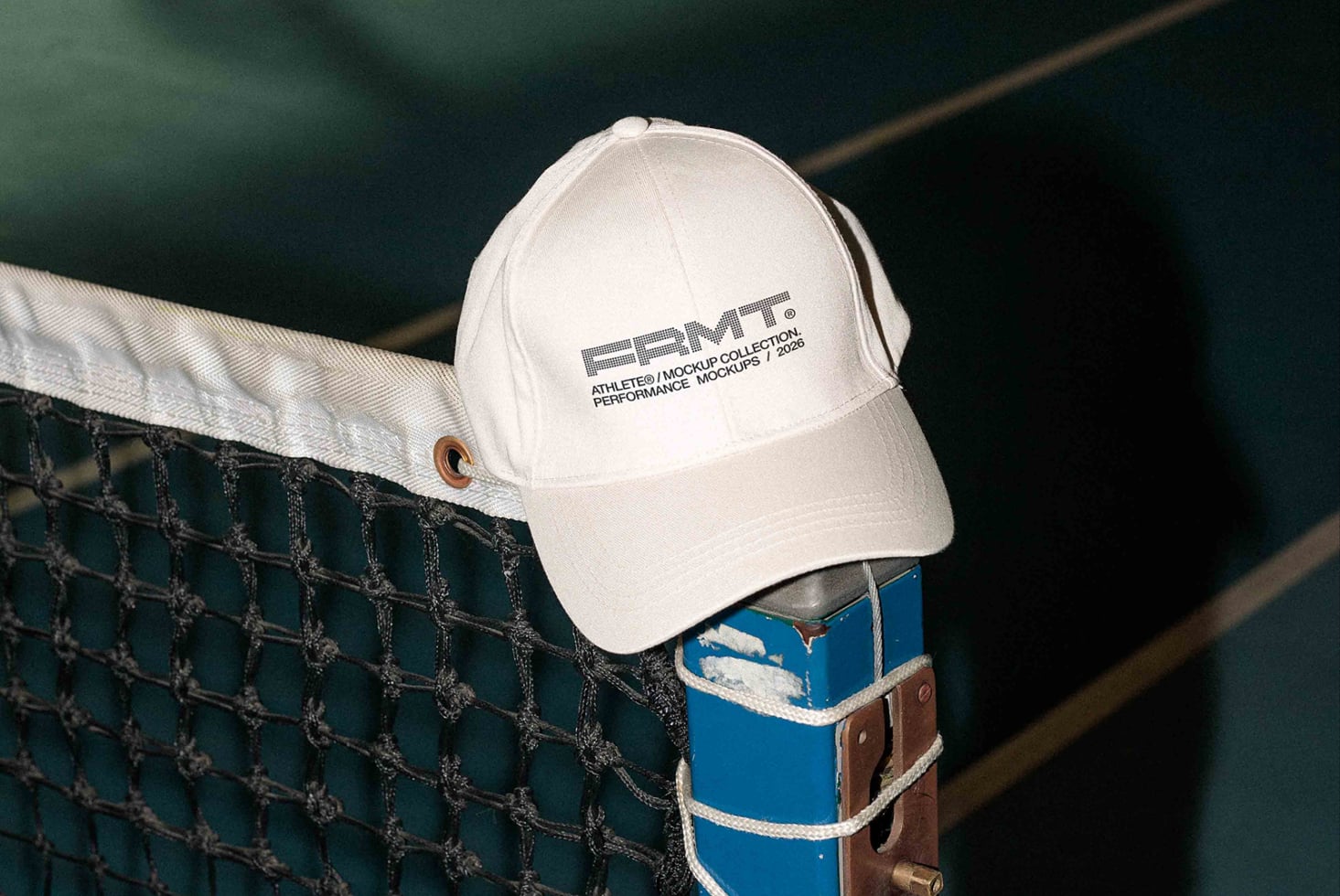 White cap on tennis net with green court visible behind