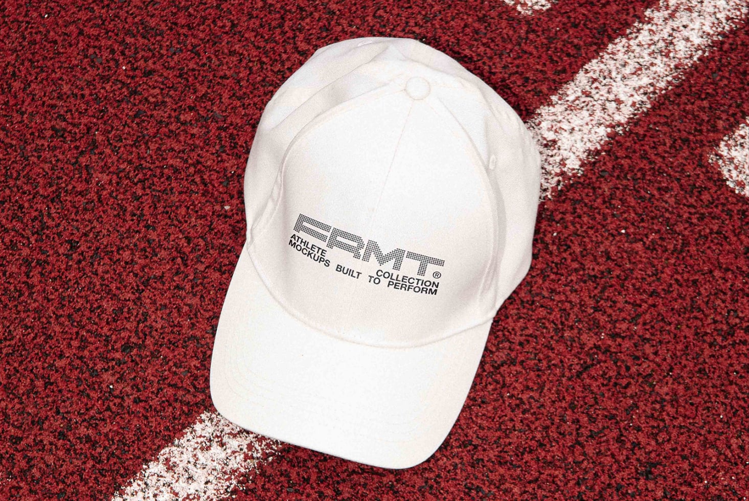 White cap flat lay on red asphalt with white line markings